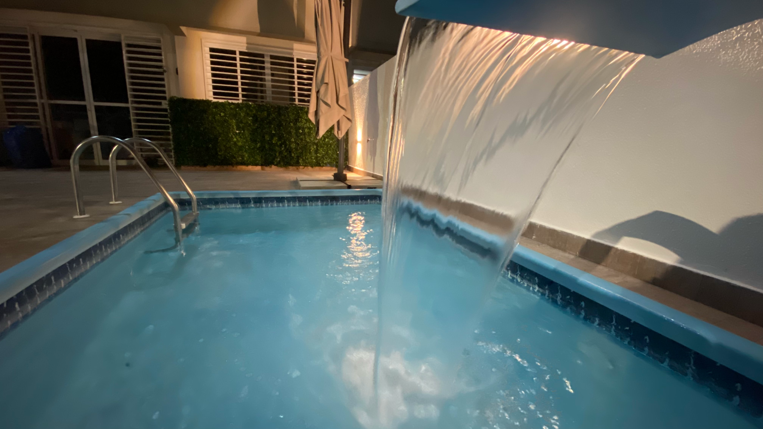 Private swimming pool with waterfall feature at luxury Airbnb investment apartment in Ponta Negra, Natal Brazil.
